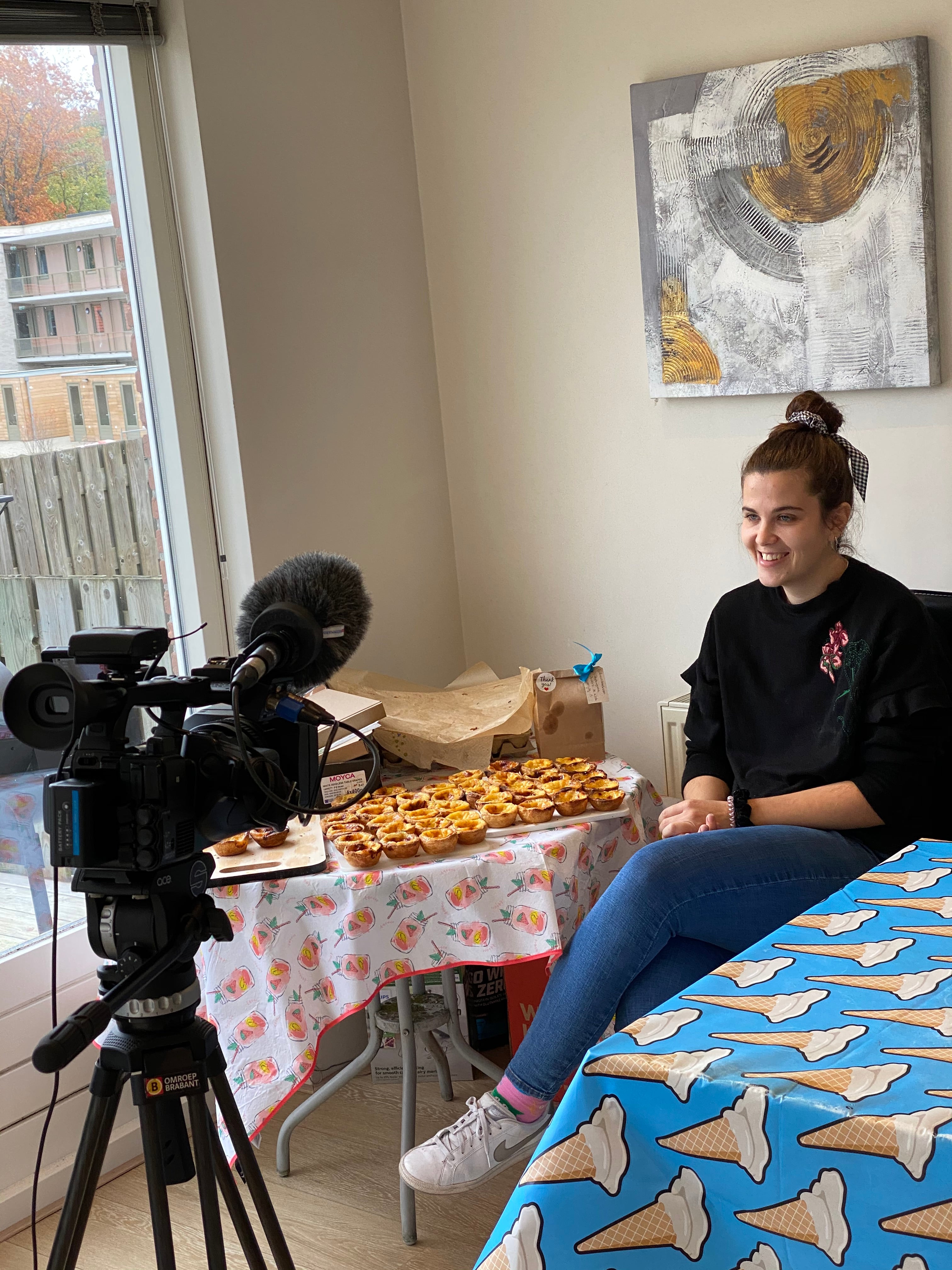 Gravação de entrevista sobre a The Custard Cookies, com microfones e cookies em destaque na mesa.